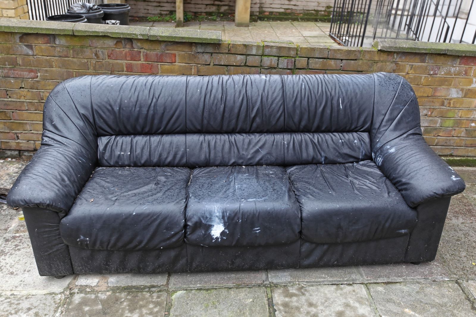 Black leather couch and sofa set out at the curb for pickup