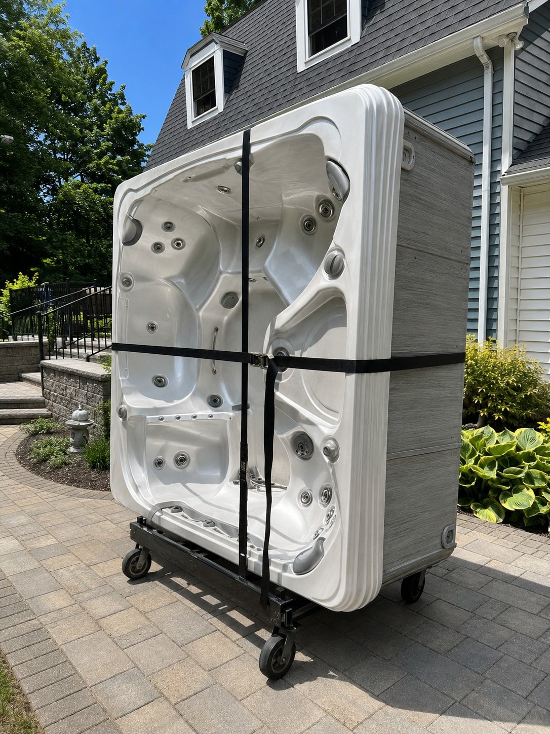 Old hot tub strapped to a dolly for haul-away