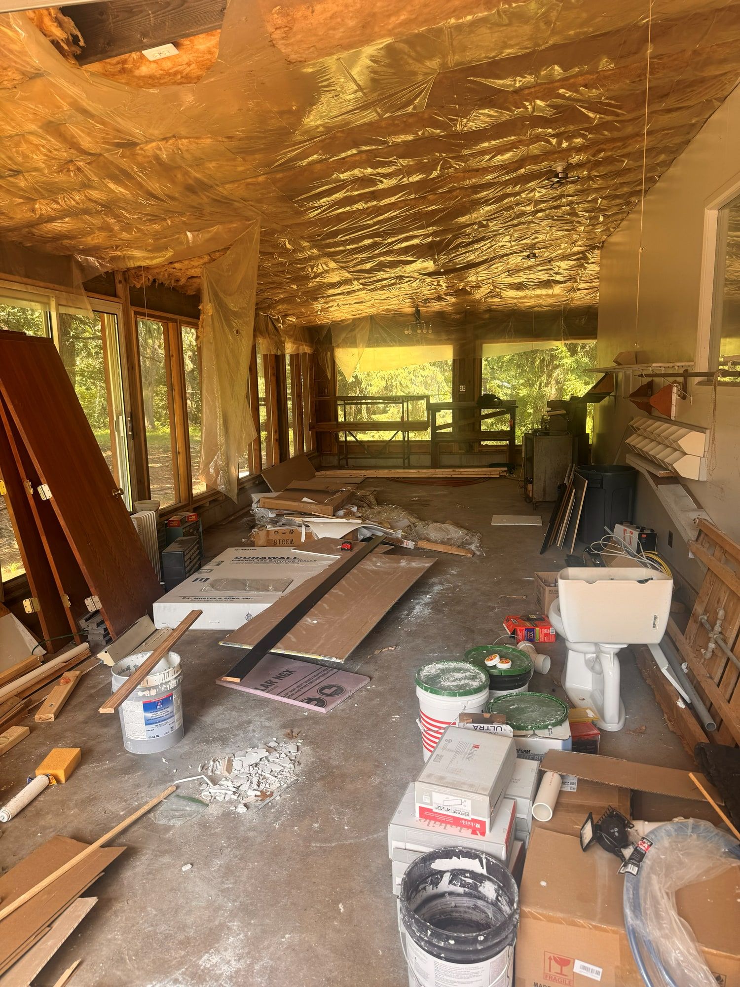 Sunroom filled with renovation debris and scrap before cleanup