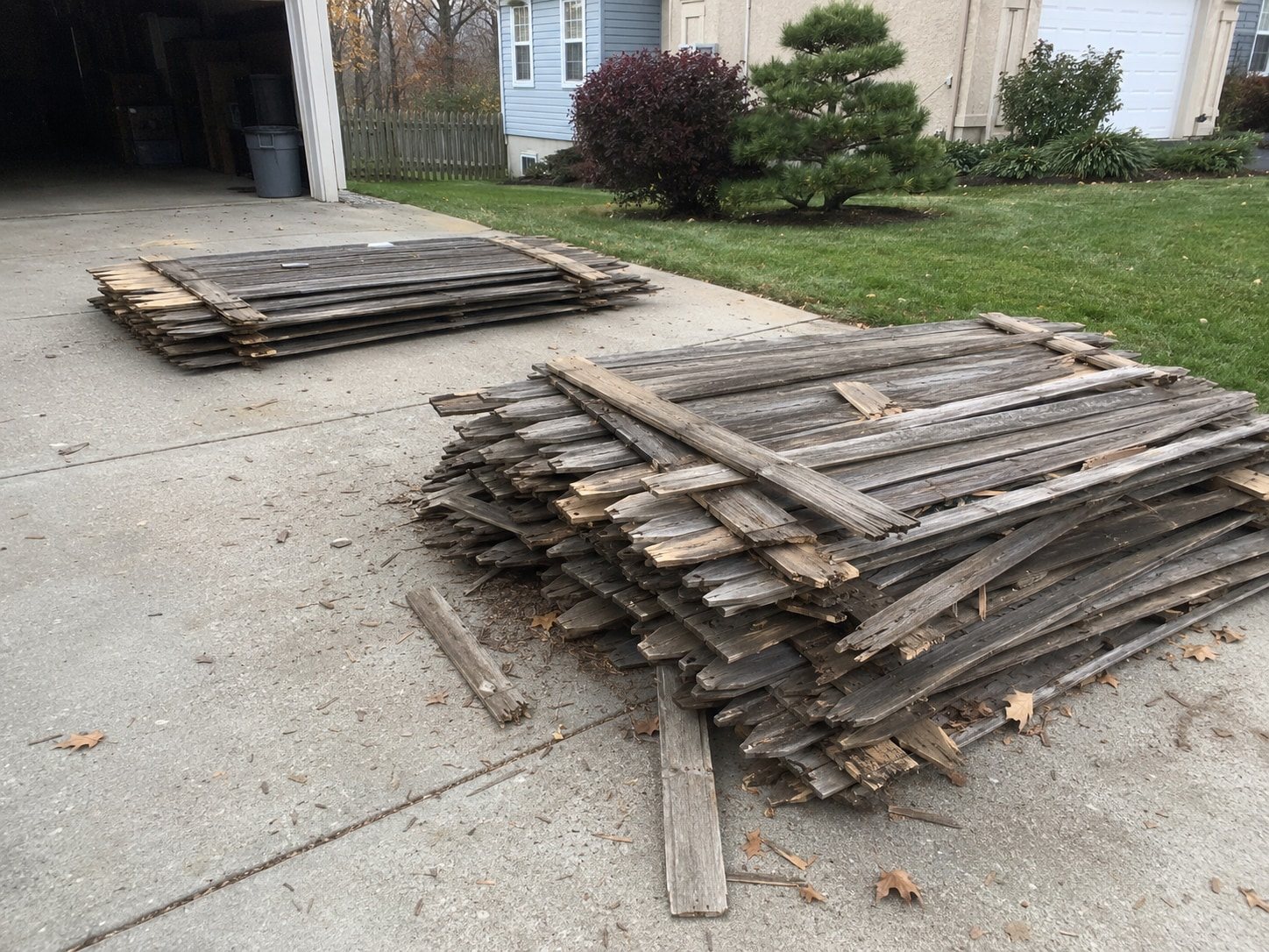 Torn-out fence pickets stacked in a yard
