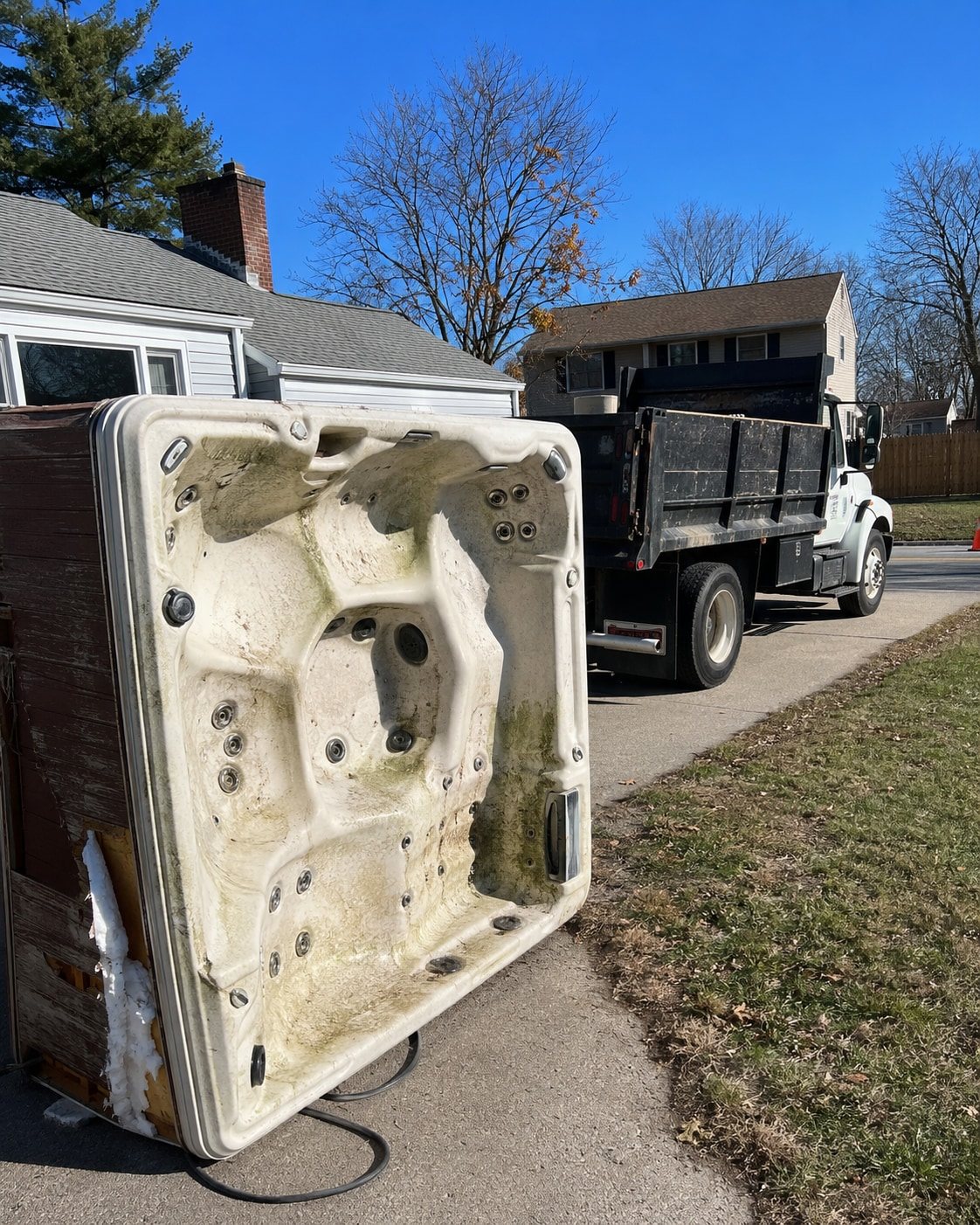 Hot tub tipped against a dump truck during removal