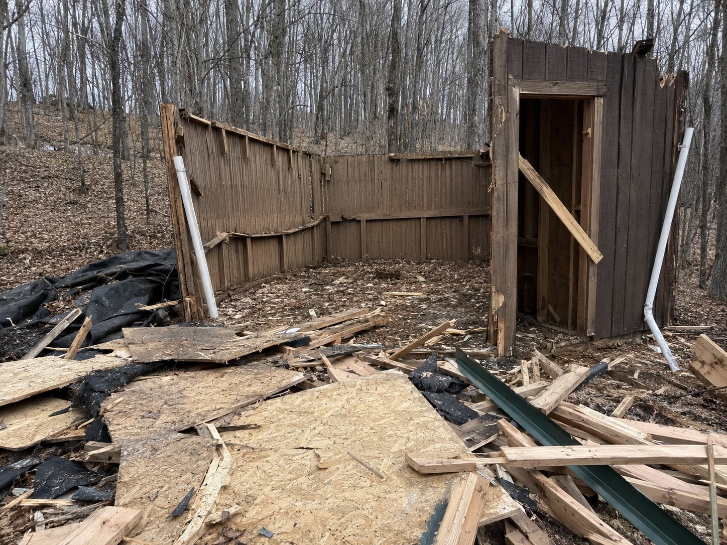 Collapsed shed and damaged fence awaiting removal