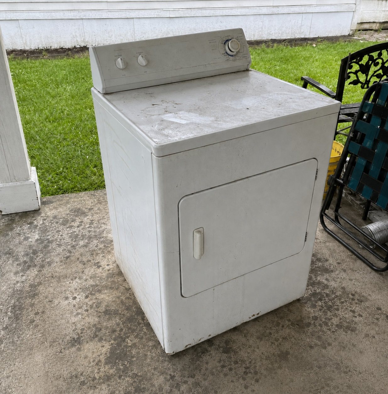 Old dryer sitting on a driveway for pickup